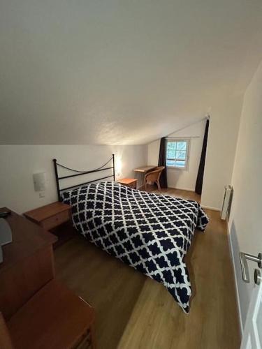 une chambre avec un lit avec une couette noire et blanche dans l'établissement Charmante maison dans résidence avec piscine proche golf et plage, à Moliets-et-Maa
