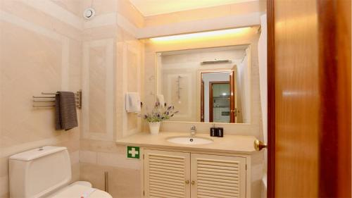 Un baño con lavabo, inodoro y espejo. en Al Charb TopFloor sea view, ar con, pool - CleverDetails, en Vilamoura