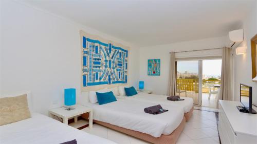 Una habitación de hotel con dos camas y balcón. en Al Charb TopFloor sea view, ar con, pool - CleverDetails, en Vilamoura