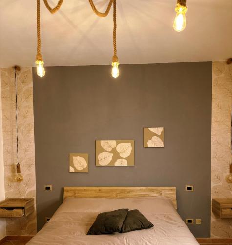 1 dormitorio con 1 cama con 3 cuadros en la pared en Il Bollore House, en Bagni San Filippo