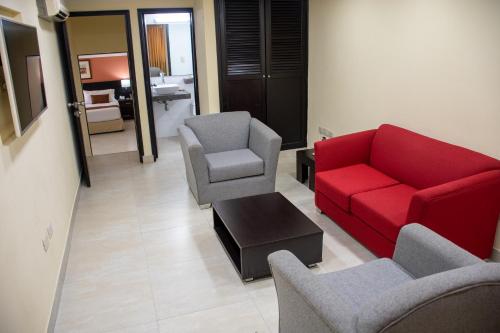 a living room with a red couch and two chairs at Hotel Arizona Suites Cúcuta in Cúcuta