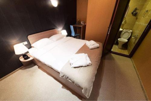 1 dormitorio con 1 cama con toallas en VIP apart 798, en Tiflis