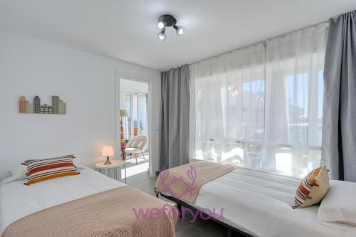 um quarto com 2 camas e uma grande janela em weforyou Fuengirola Center Sunny & Beach em Fuengirola