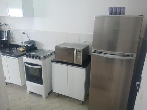 a kitchen with a microwave and a stove at Apartamento Vista Mar Praia Grande, Ocian in Praia Grande