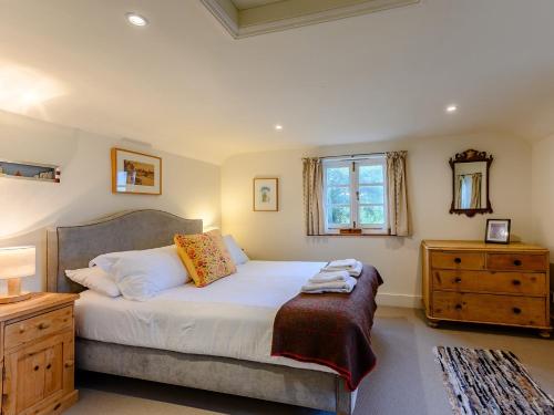 a bedroom with a bed and a dresser and a window at 3 Bed in Isle of Purbeck IC081 in Langton Matravers
