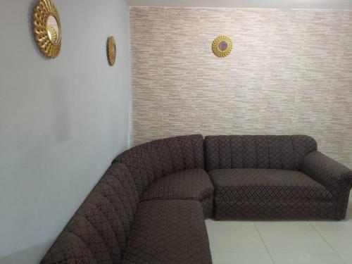 a brown couch in a room with a wall at Habitaciones en apartamento central, cerca de sitios turísticos Jardín Botánico y metro estación universidad in Medellín