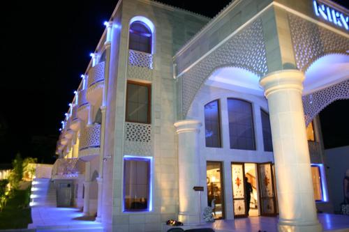 a large building with lights on it at night at Familly Art Hotel Nirvana in Shumen