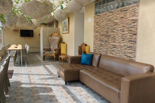 eine Lobby mit einem Sofa, einem Tisch und Stühlen in der Unterkunft Hotel Casa Botero 102 in Bogotá