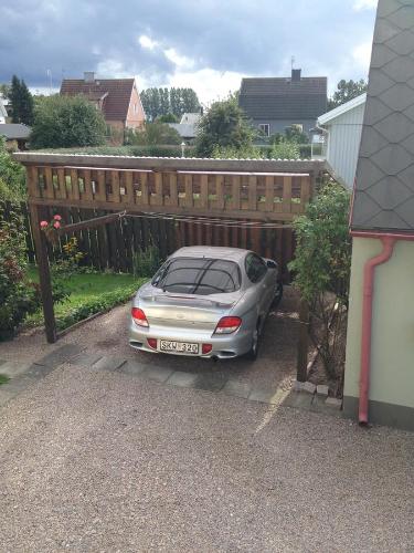 a car parked in front of a wooden fence at Vivans Bed and Self catering in Kristianstad