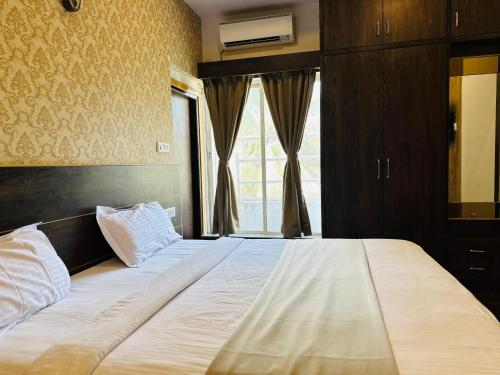 a large bed in a bedroom with a window at Hotel Classio Koramagala in Bengaluru