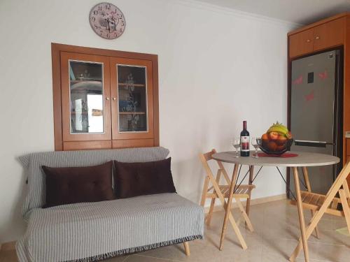 a living room with a chair and a table with a clock at Aggeliki's House in Symi