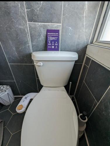 a white toilet in a bathroom with a sign on it at The 2D Spot! in Buffalo