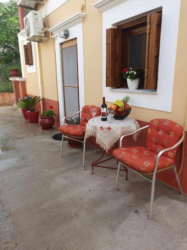 a table with two chairs and a bottle of wine at Aggeliki's House in Symi