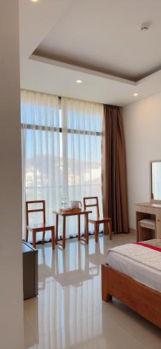 a bedroom with a bed and a table and chairs at Hotel Minh Thắng in Vung Tau