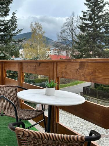 a table and chairs on a balcony with a view at Villa na Dolnej in Karpacz