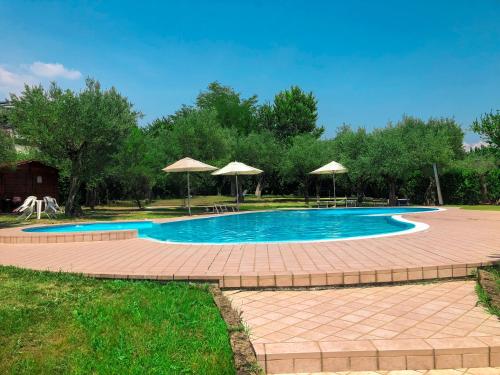 una piscina con mesas y sombrillas en un patio en AHG Riva Del Sole Hotel, en Moniga del Garda