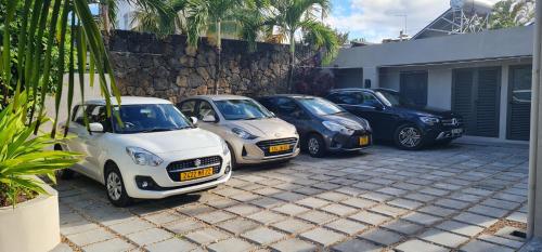 three smart cars parked next to a building at Blue Ocean Suites & Apartments in Trou dʼ Eau Douce