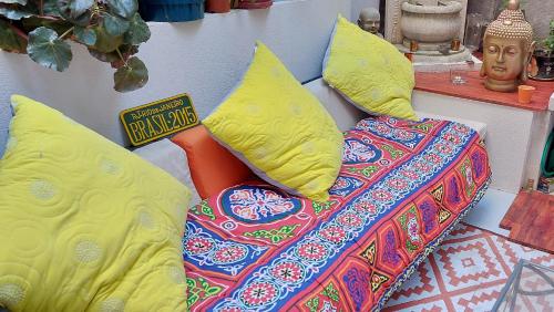 Una cama con almohadas amarillas encima. en Cosy Appart en Marsella