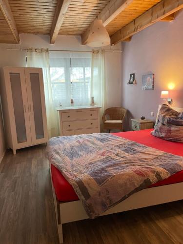 a bedroom with a large bed with a red blanket at Ferienwohnung Bodensee in Hohenfels