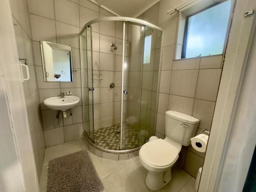 a bathroom with a shower and a toilet and a sink at Busa House in White River