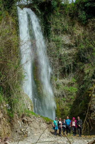 a group of people standing in front of a waterfall at Djurdjevina Family Farm in Kolašin