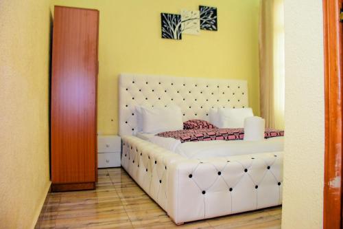 sypialnia z dużym białym łóżkiem w pokoju w obiekcie MONTANA STAY w Ruhengeri