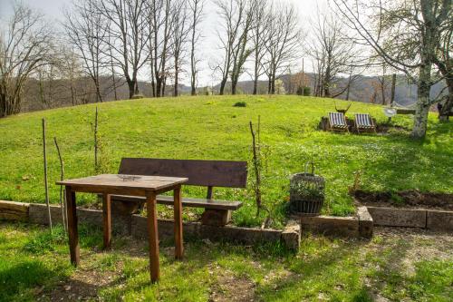 a picnic table and a bench in a field at Djurdjevina Family Farm in Kolašin