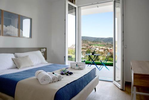 una camera da letto con un grande letto con asciugamani di Le Nereidi Green Resort Elisa a Sirolo