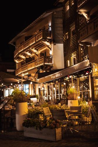 a restaurant with tables and chairs in front of a building at Coeur de Megève in Megève