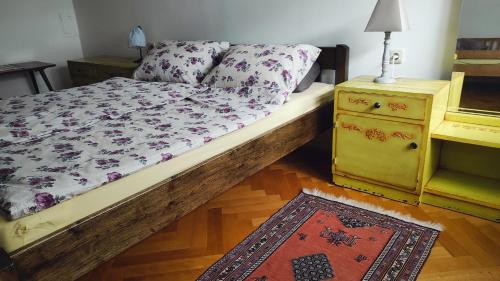 a bedroom with a bed with a dresser and a rug at Vintage & Cozy Apartment in Varaždin
