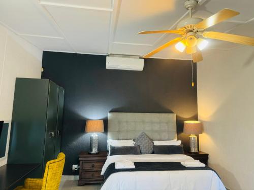 a bedroom with a bed and a ceiling fan at Busa House in White River