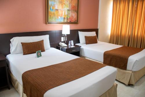 a hotel room with two beds and a telephone at Hotel Arizona Suites Cúcuta in Cúcuta