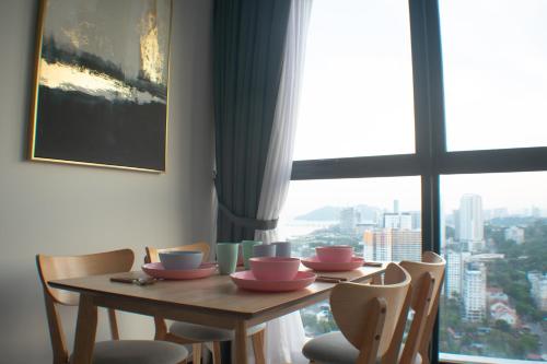 a dining room table with chairs and a large window at Prime Comfort Seaview with Netflix and Water Filter near Georgetown in Jelutong