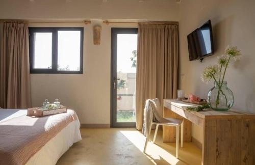 a bedroom with a bed and a desk and a television at Hotel El Teular in Sueca