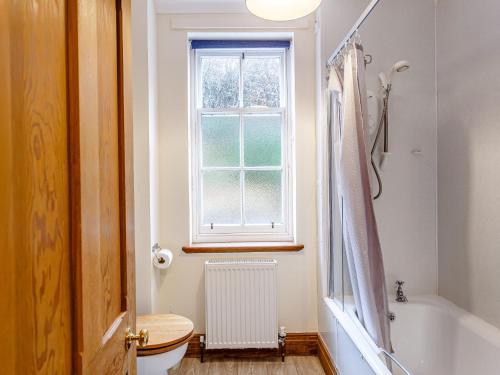 a bathroom with a toilet and a window at 6 Bed in Lairg CA210 