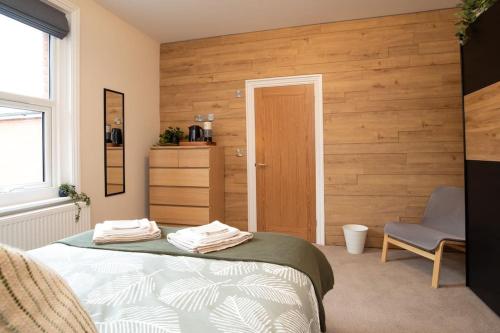 a bedroom with a bed and a chair at Green Nest Room with private bathroom in Eastbourne