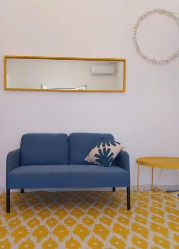 a blue couch in a living room with a table at Casa Plemmirio Varco 22 in Plemmirio