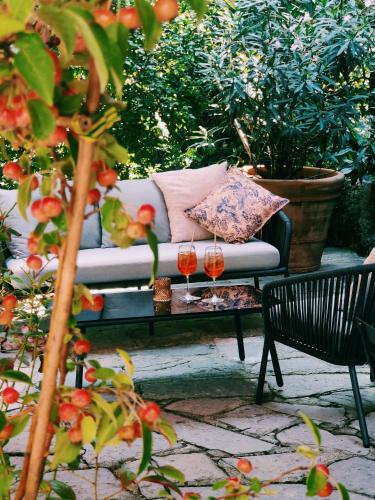 a couch and two wine glasses on a table at Dandelion Como Suites & Park in Villa Guardia