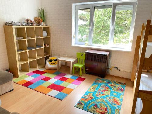 Cette chambre pour enfants dispose d'un tapis coloré et d'une table. dans l'établissement Csendes zöldövezeti, à Budapest