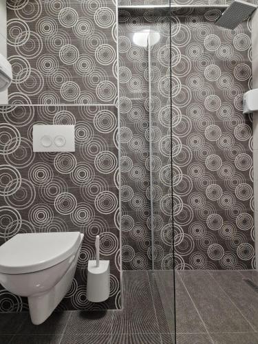 a bathroom with a toilet and a glass shower at Vila Blue Lagoon in Eforie Nord