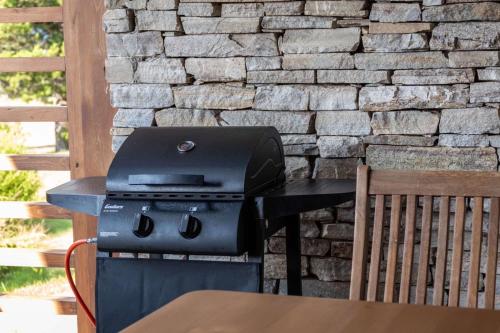 a grill sitting on a table next to a stone wall at Martini villa Lake in Razlog