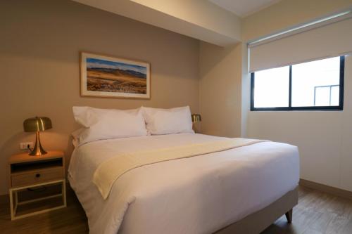 a bedroom with a large white bed and a window at Pod by Wynwood House in Lima