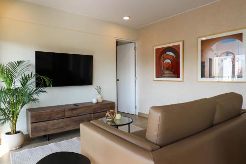 a living room with a couch and a flat screen tv at Pod by Wynwood House in Lima