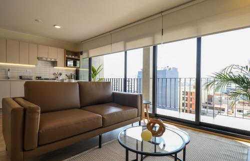 a living room with a couch and a glass table at Pod by Wynwood House in Lima