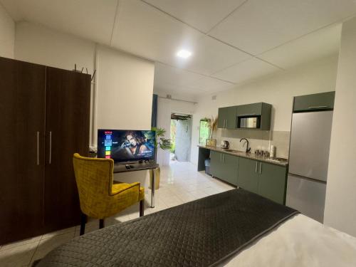 a kitchen with a desk with a tv and a chair at Busa House in White River
