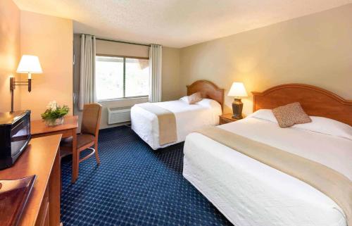 a hotel room with two beds and a television at Hotel Glenwood Springs in Glenwood Springs