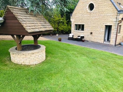 einen Pavillon inmitten eines Rasens in der Unterkunft Luxury, private, secure self-contained Coach House, near Wythall and close to the NEC in Tanworth