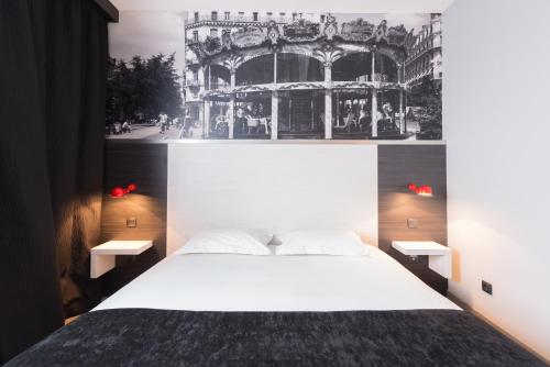 um quarto com uma cama branca e uma fotografia na parede em Hôtel des Lumières Lyon Meyzieu Arena Stadium em Meyzieu