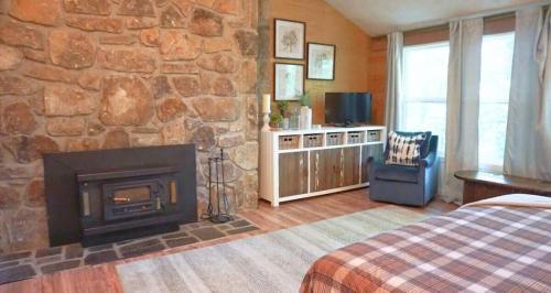 a bedroom with a fireplace and a stone wall at Shady Woods Cabin in Gatlinburg