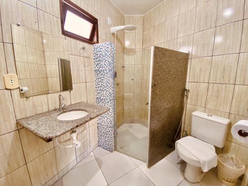 a bathroom with a toilet and a sink and a shower at Hotel Porto das Ancoras in Porto Seguro